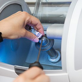 Dental crown being removed from CEREC milling machine